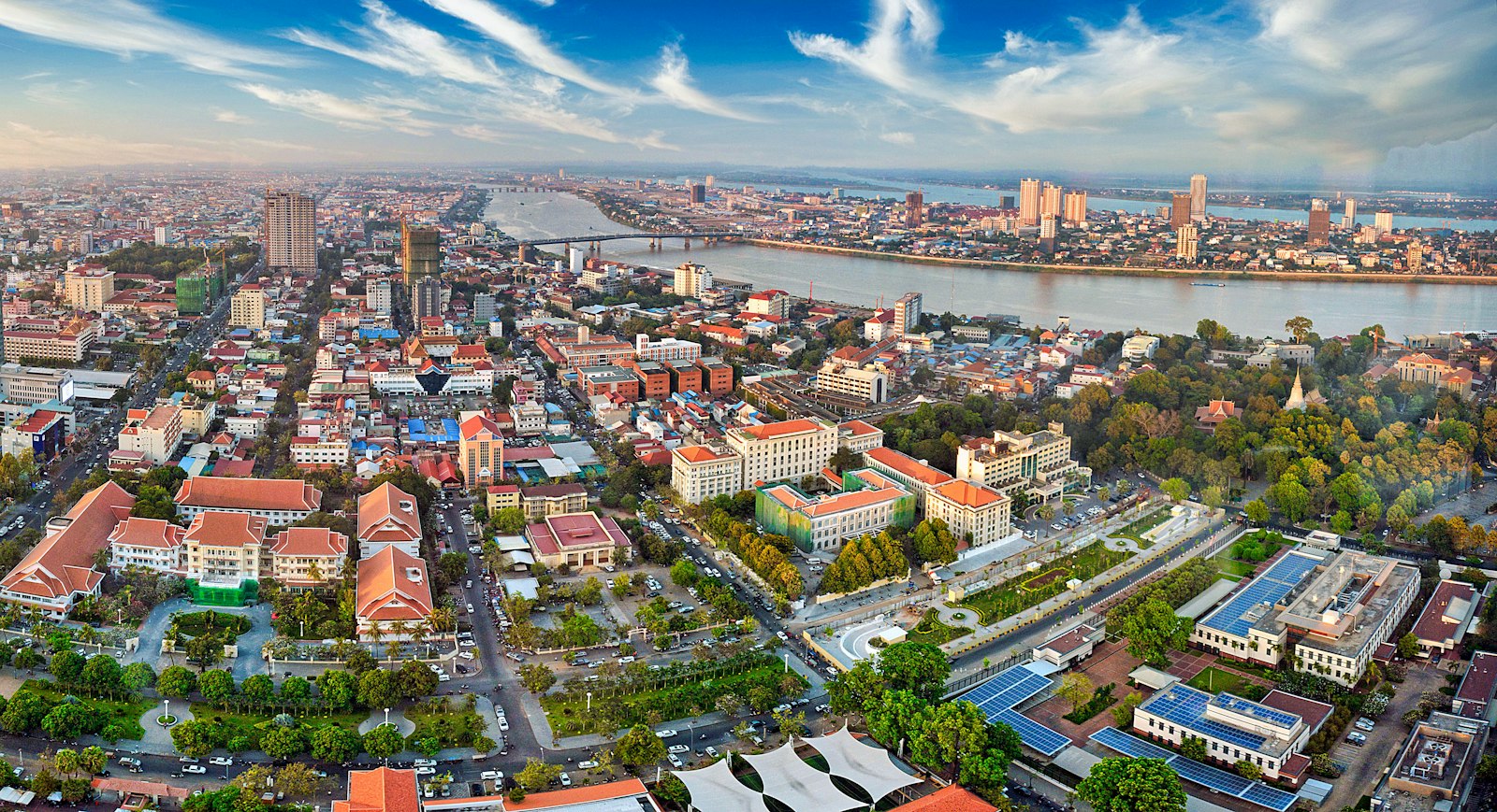 Aerial view of Phnom Penh: the Mekong riverfront, colonial-era buildings and modern towers behind them.